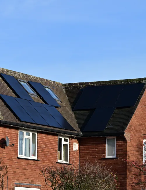 A red brick house with solar panels on its roof
