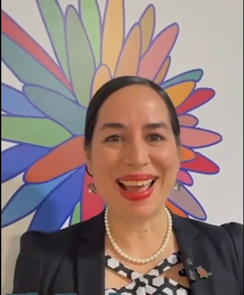 Paola Fajardo smiling in front of COP16 logo