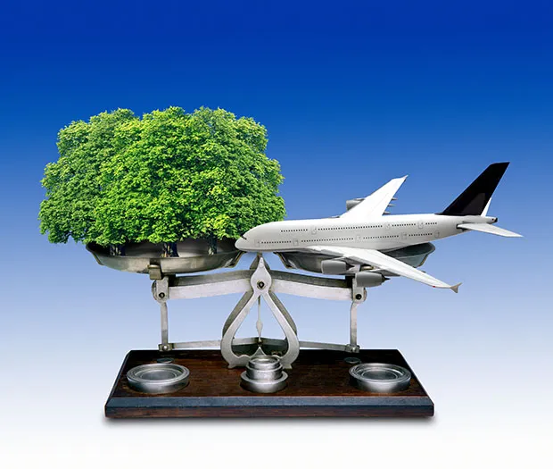 Weighing scales with tree on one side and aeroplane on other side