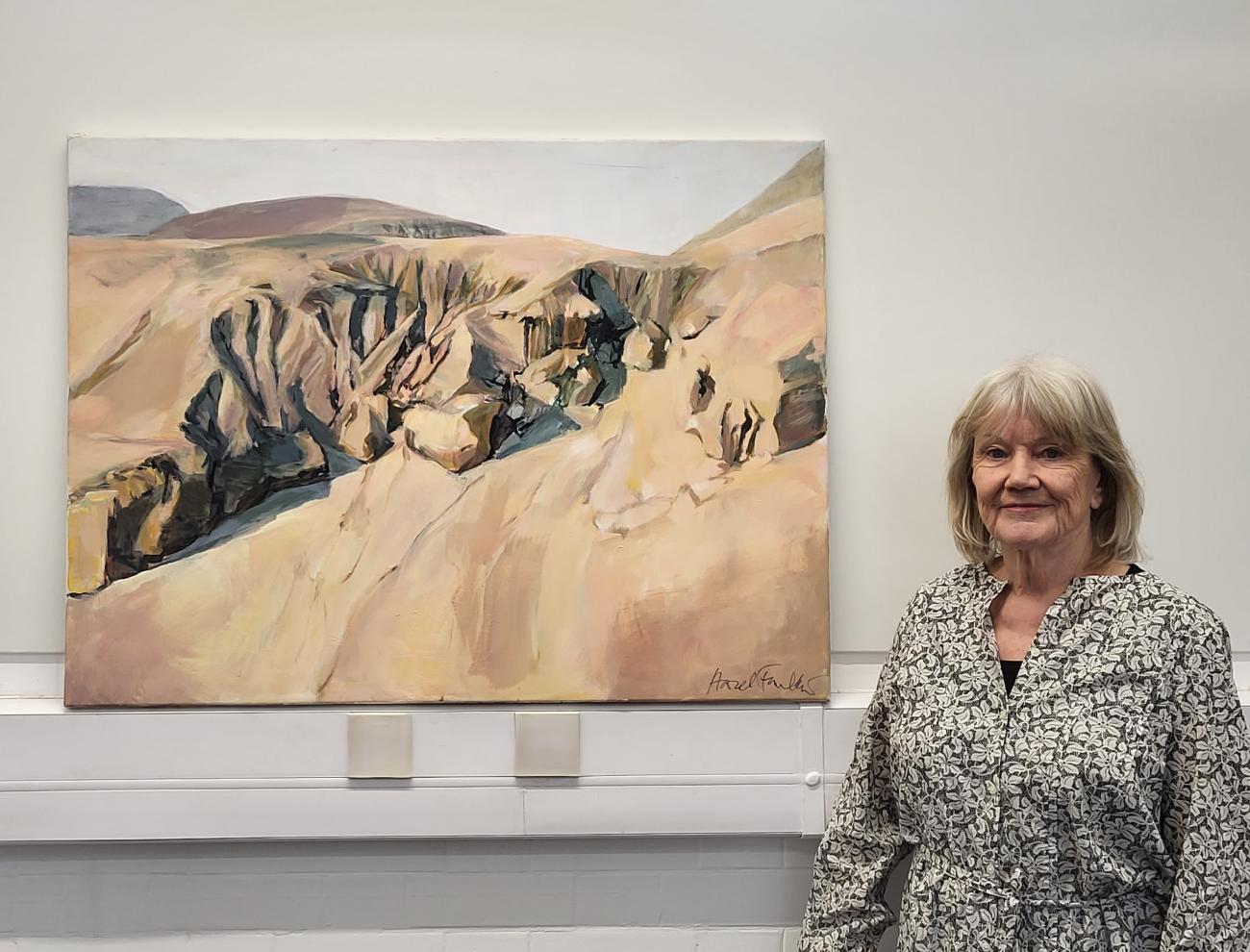 Artist Hazel standing next to her painting