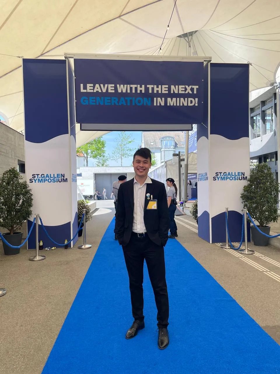 Zihan Xuan on a blue carpet below a sign saying 'Leave with the next generation in mind'