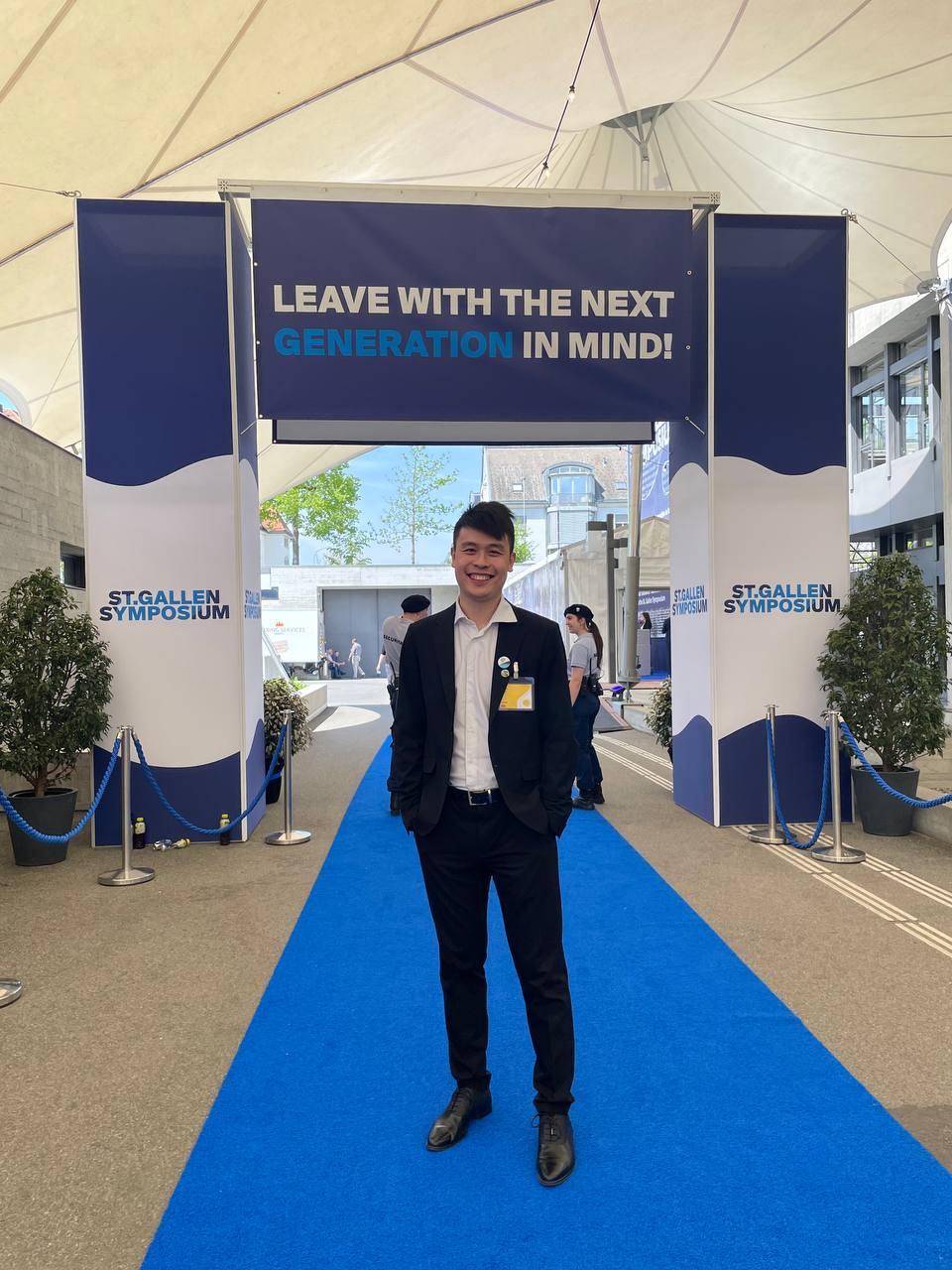 Zihan Xuan on a blue carpet below a sign saying 'Leave with the next generation in mind'