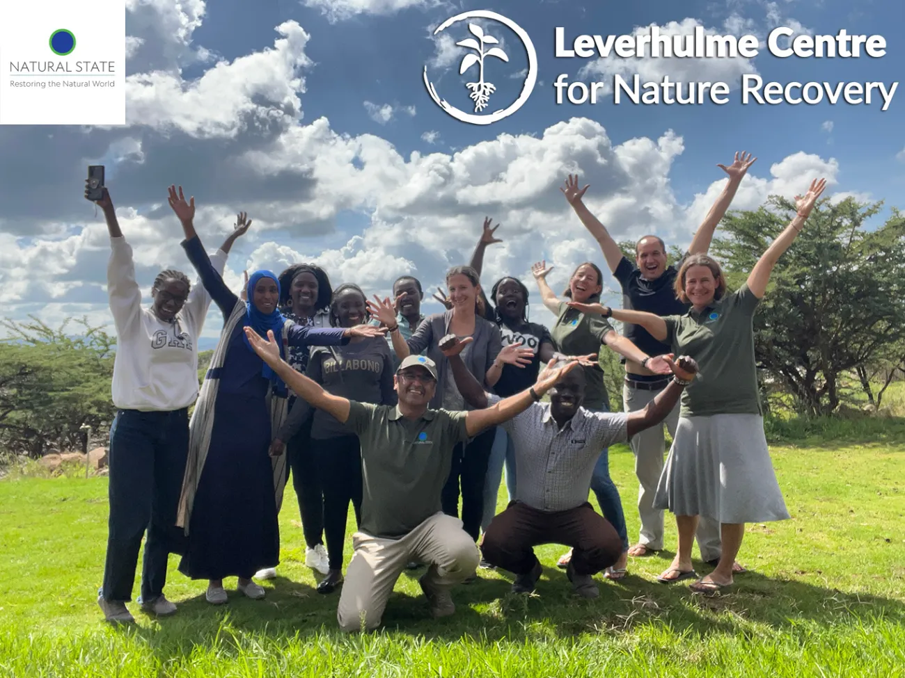 Colleagues from both organisations in a group with arms raised