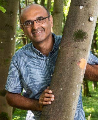 Professor Yadvinder Malhi leaning on a tree