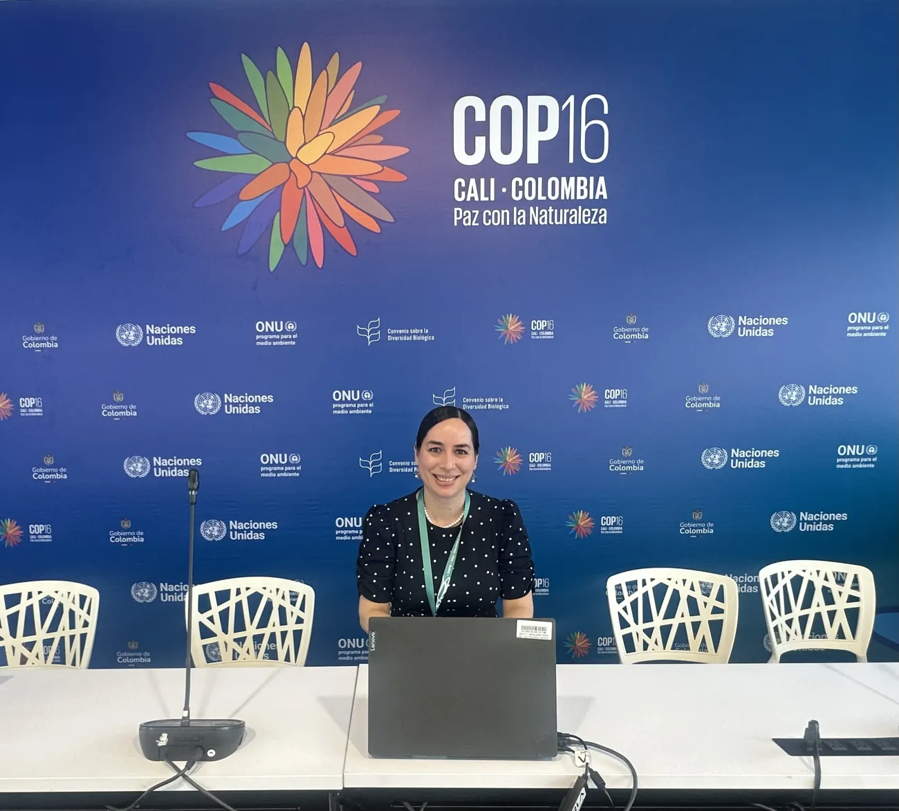 Paola Fajardo smiling in front of COP16 logo