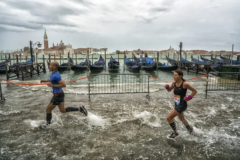 Venice marathon runners speeding through calf height water