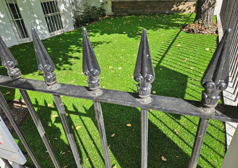 Artificial grass behind wrought iron railings