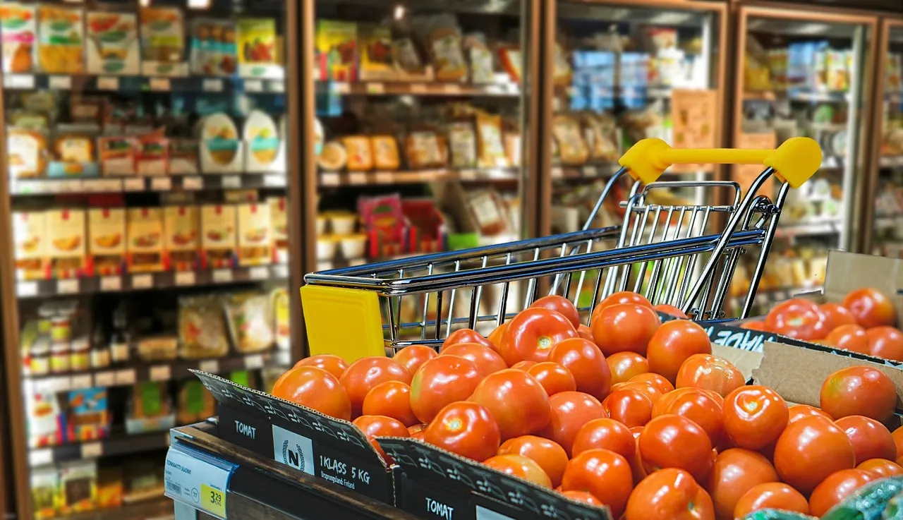 Close up of tomatoes with a trolley and food in the background