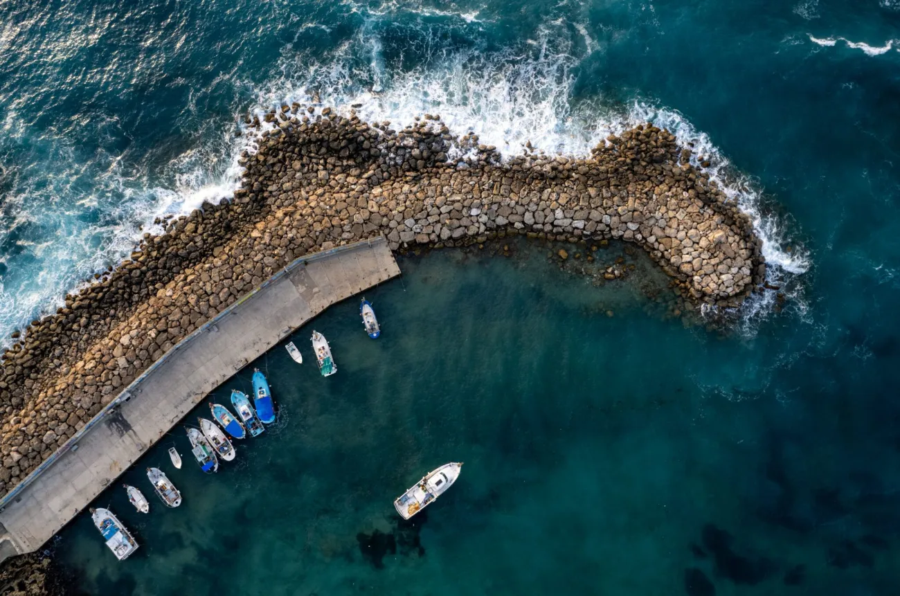 Aerial view of Aerial drone view of fishing boats moored at a harbour during breakwater