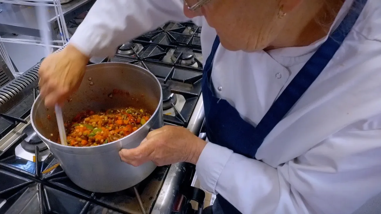 School chef stirring a pot of food