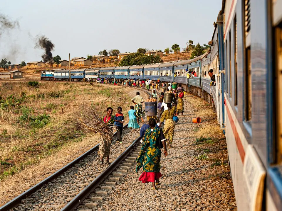 People walking along the tracks of the Tazara Railway in Zambia which connects the port of Dar es Salaam in east Tanzania with the town of Kapiri Mposhi in Zambia. 