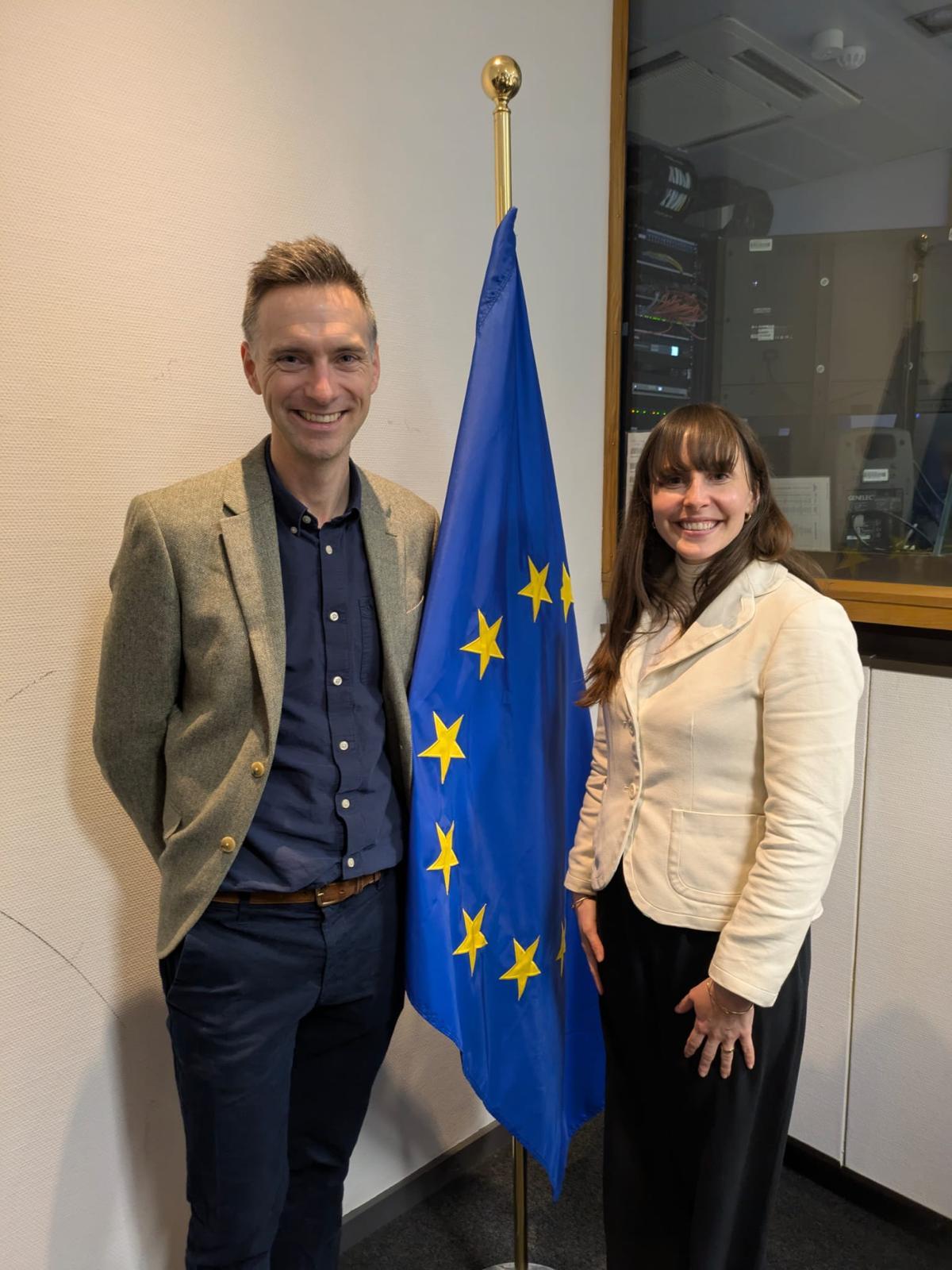 Dr Sam Hampton stood next to Cassie Etter-Wenzel and also a European Commission flag