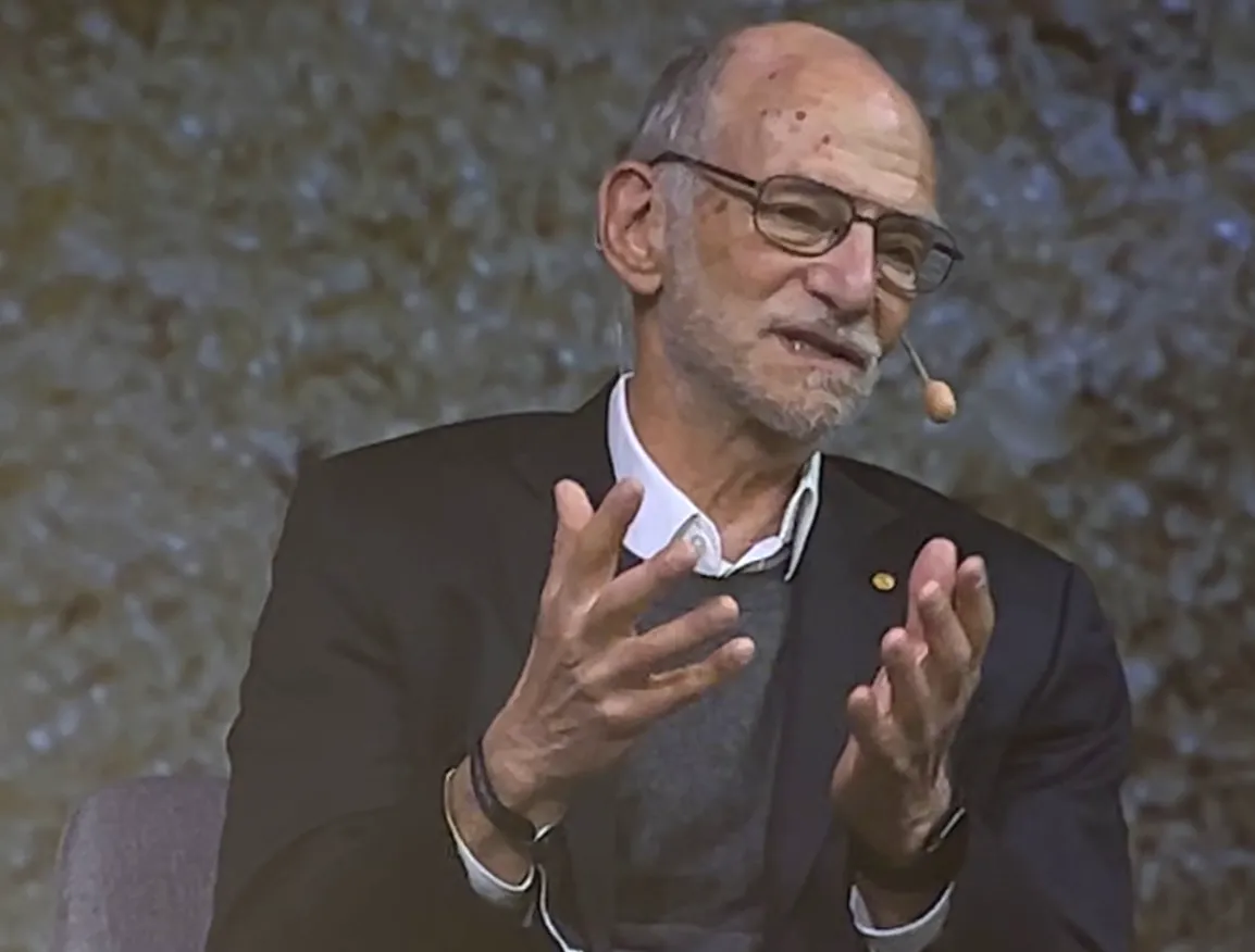 Nobel Laureate in Physiology or Medicine (2017), Michael Rosbash, speaking expressively with both hands raised during a panel discussion