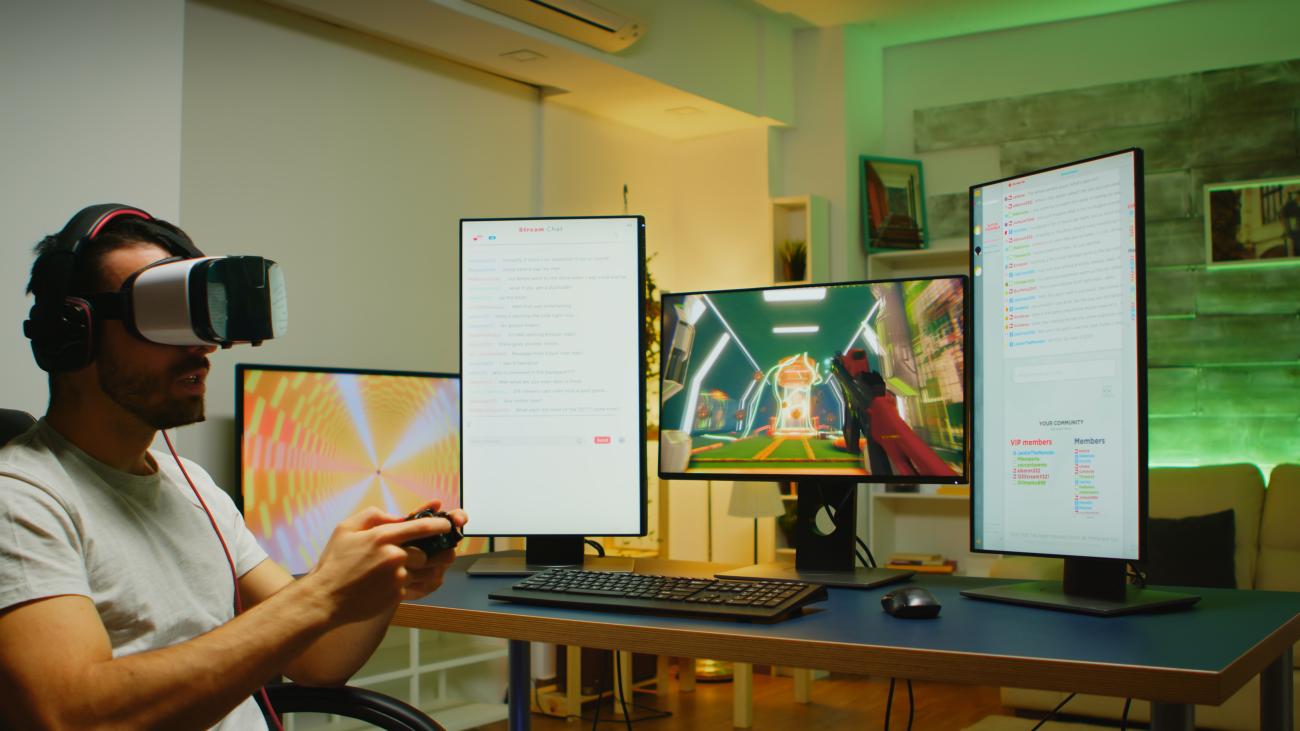 Professional gamer playing games wearing a virtual reality headset in front of multiple screens