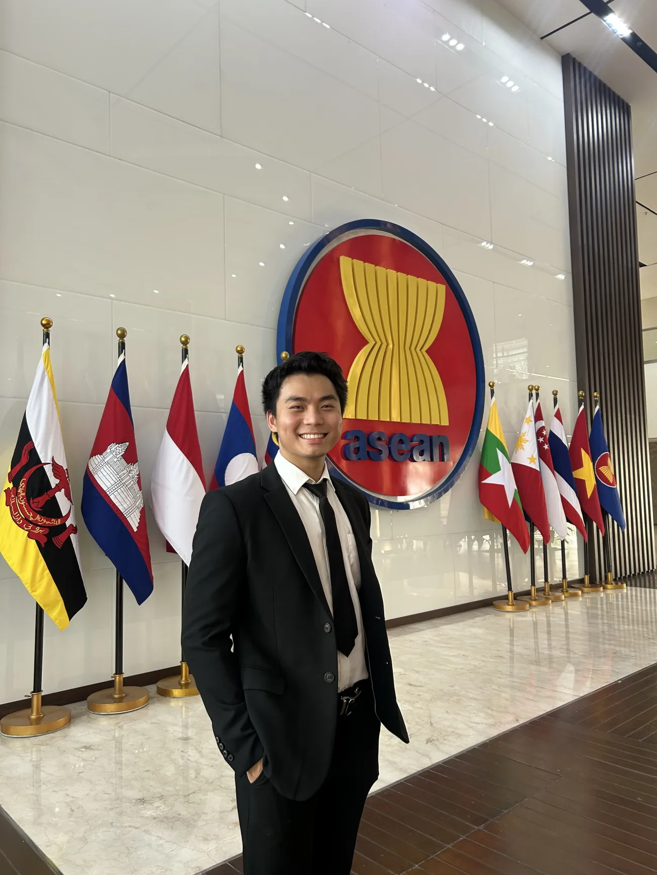 Max Han stood near the ASEAN sign surrounded by flags