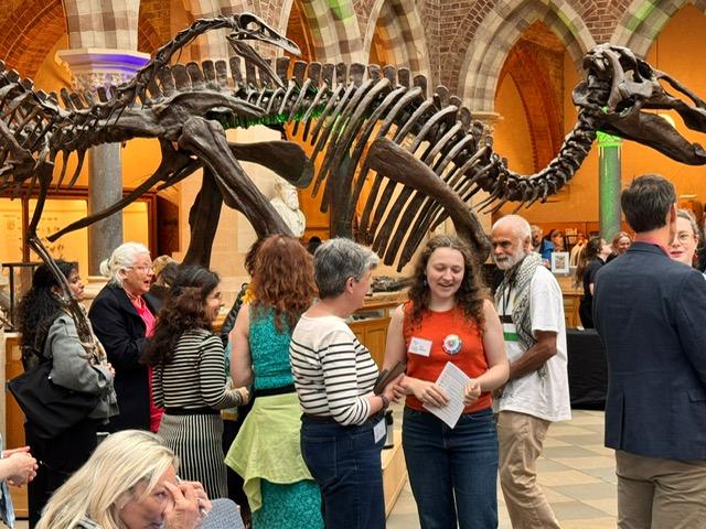 Event participants chatting in front of one of the dinosaur exhibits at the Oxford University Museum of Natural History