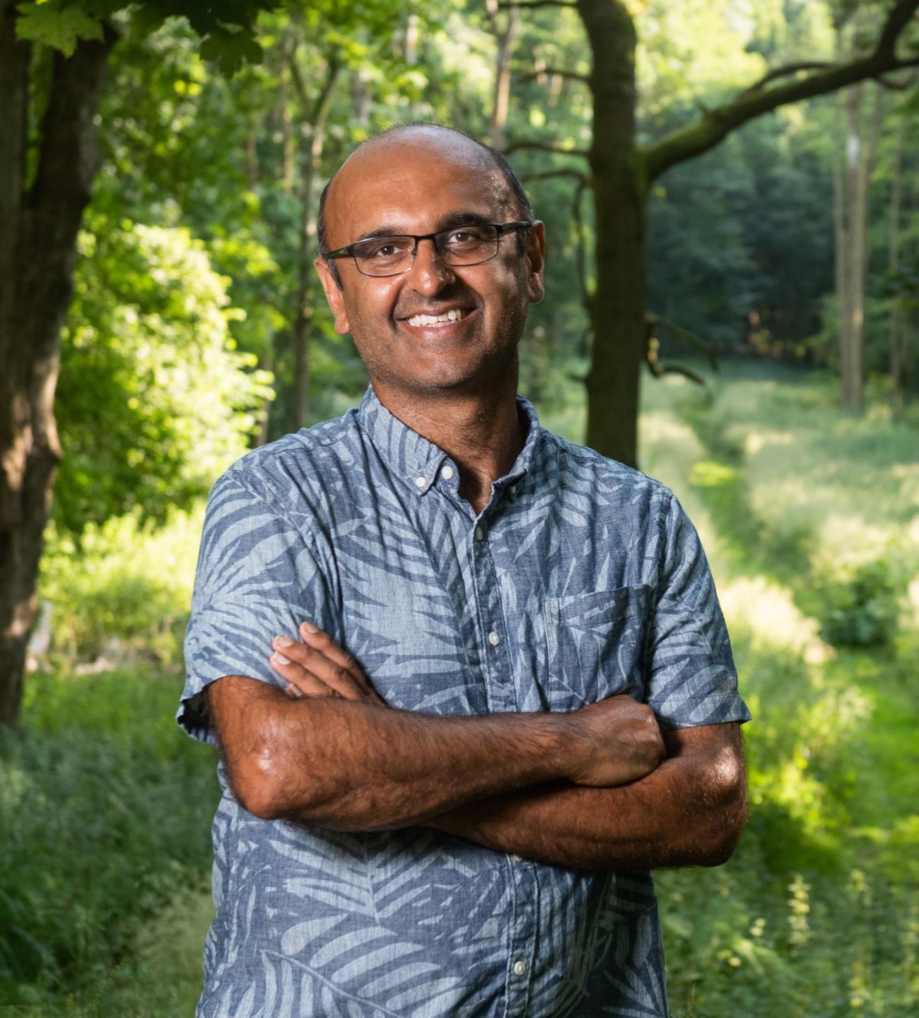 Professor Yadvinder Malhi smiling in a forest