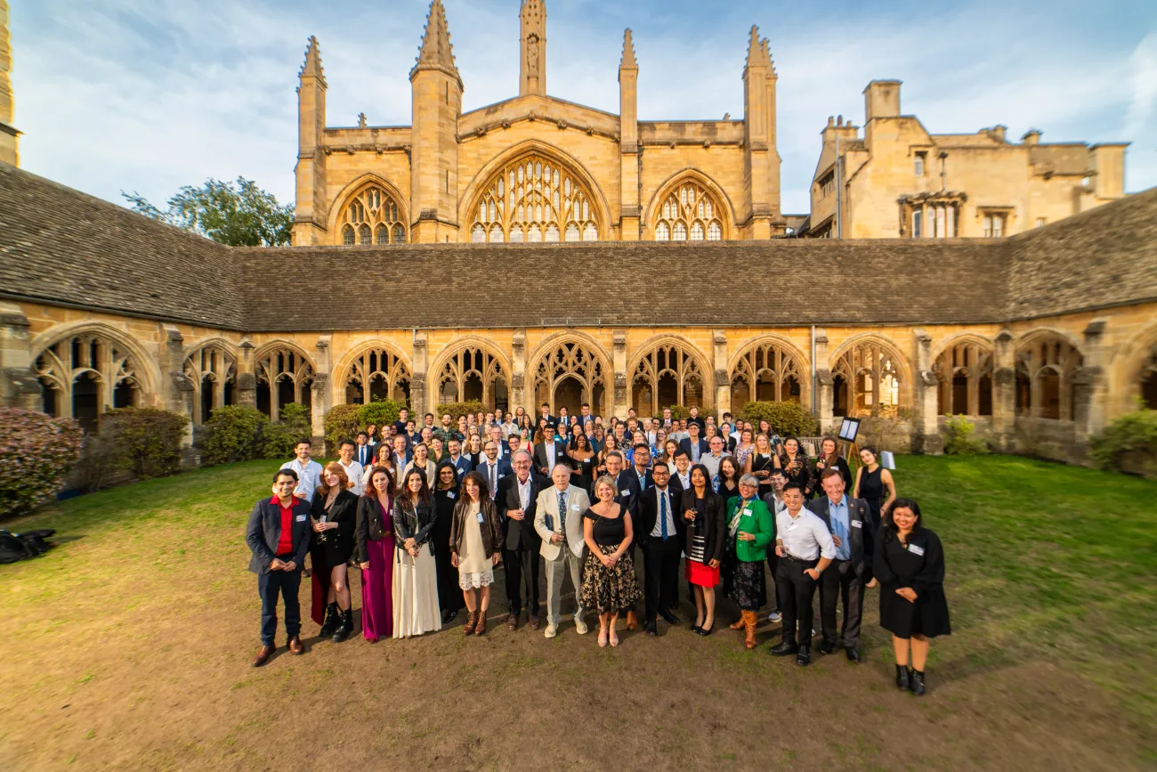 Group shot of all attendees outside the college before the dinner with building in background