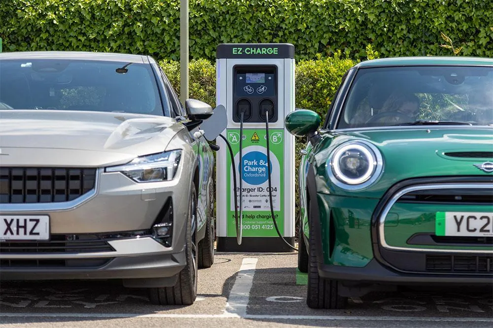 Two cars parked next to an EV charger