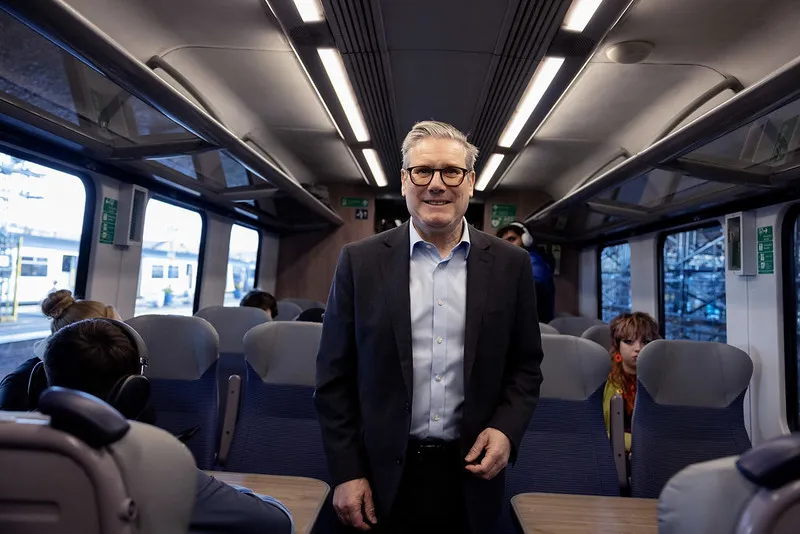 Prime Minister Keir Starmer standing in a train carriageway on his way to West Yorkshire