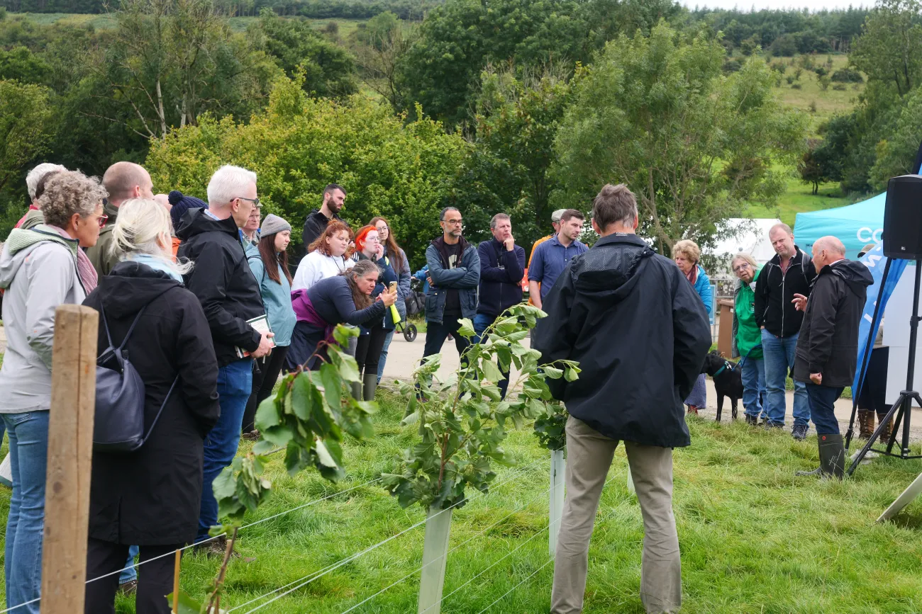 Event attendees listening to a speaker in a field