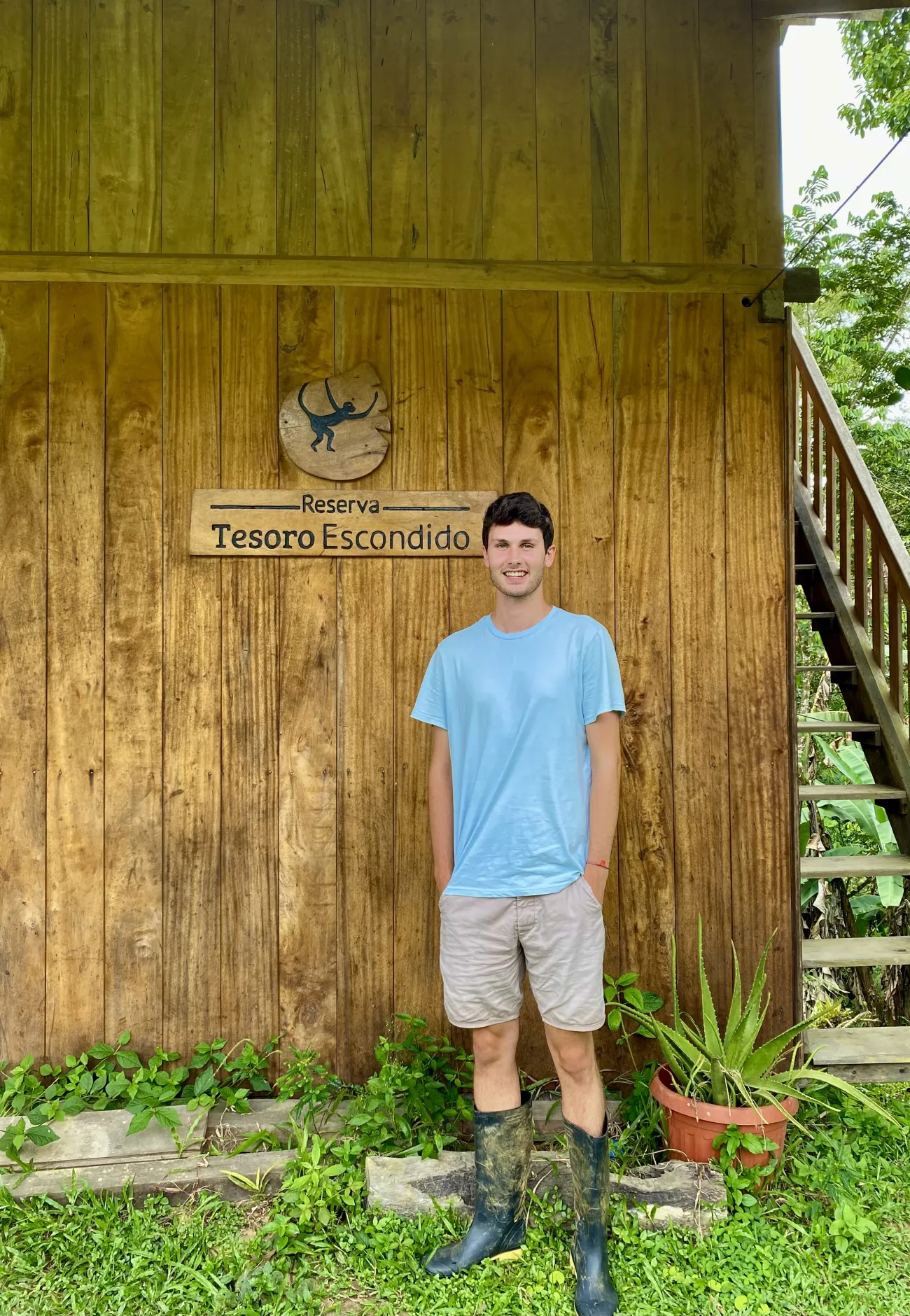 Toby Bliss standing outside one of the huts at the reserve