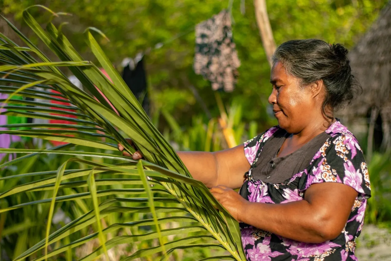 A woman in Burariki, Kiribati, involved in ocean-based activities with palms to provide for their families. 