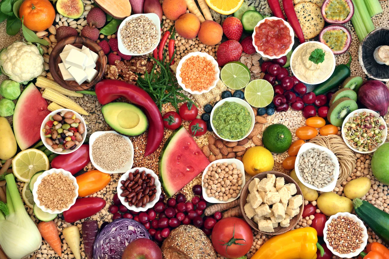 Aerial view of large vegan health food collection with foods high in protein, vitamins, minerals, anthocyanins, antioxidants, fibre, omega 3 and smart carbs.