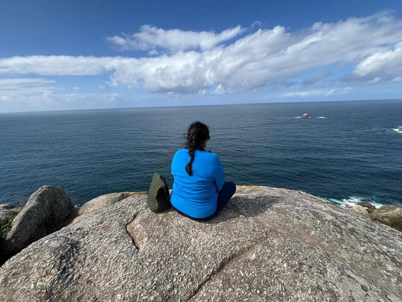 Angela Soasti Pozo sat on a rock looking out to sea with her back to the camera