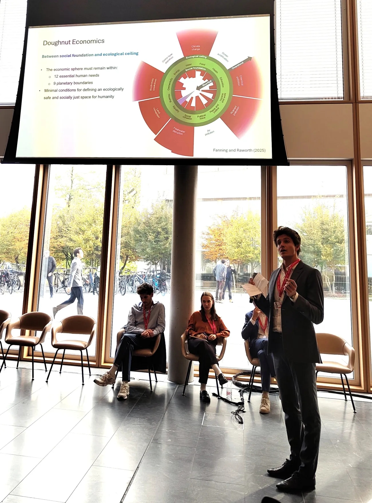 Youth delegates discussing pluralist approaches to economics, reimagining human and planetary well-being.