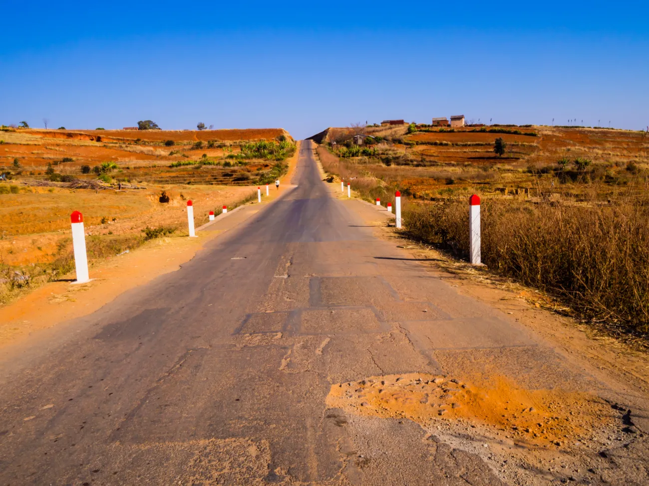  Panoramic paved road with dusty potholes leading to Morondava, Madagascar 