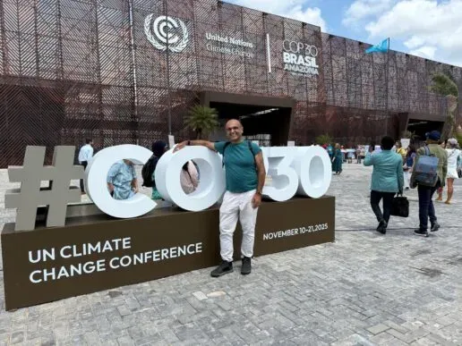 Professor Yadvinder Malhi standing next to a large 3d COP30 sign