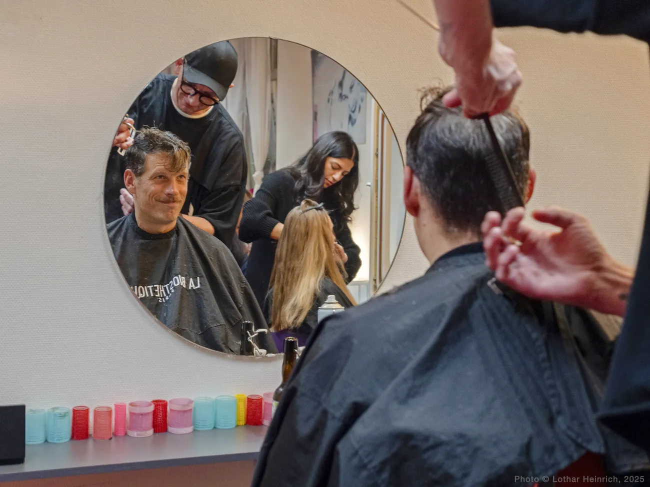 Man having hair cut in front of a mirror by hairdresser
