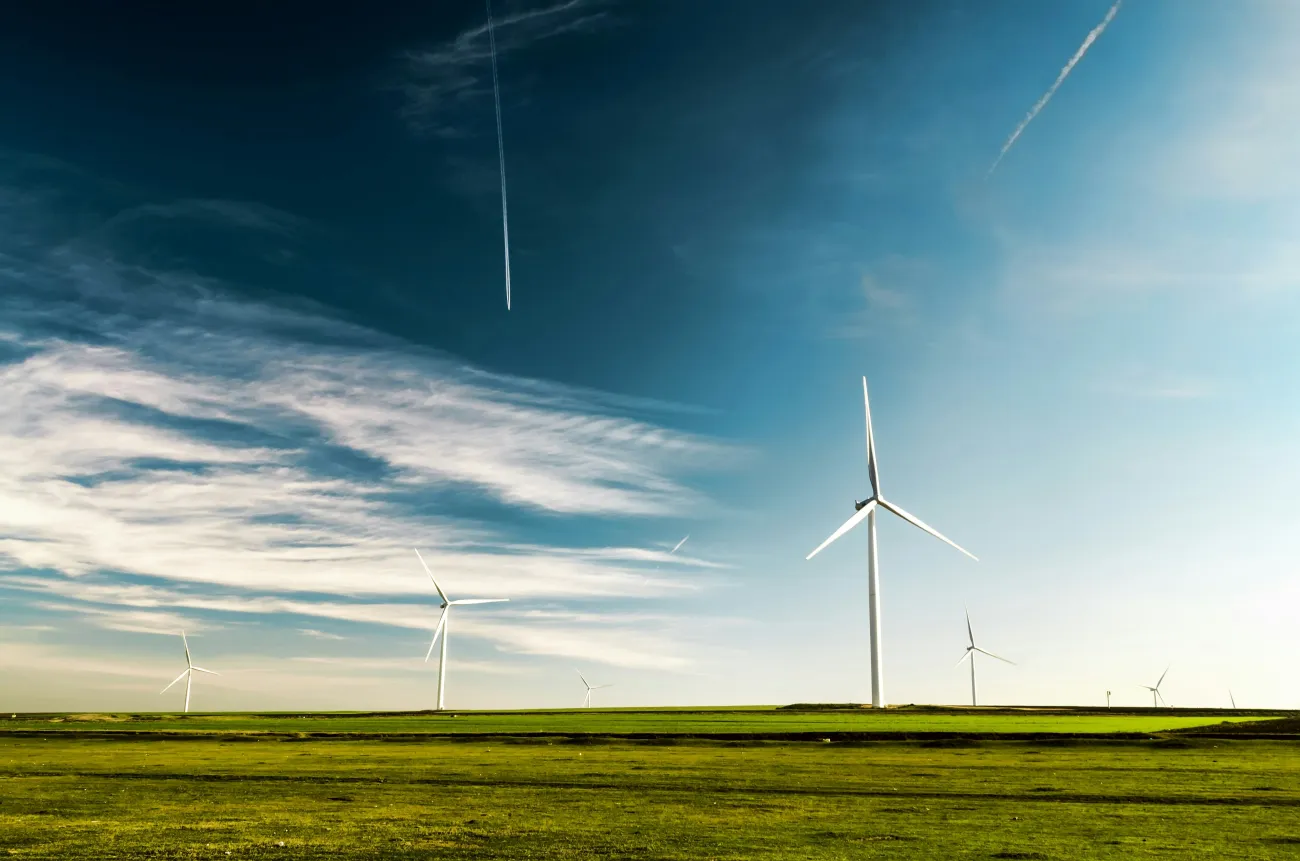 Landscape showing windturbines with moody dark sky and dark green grass