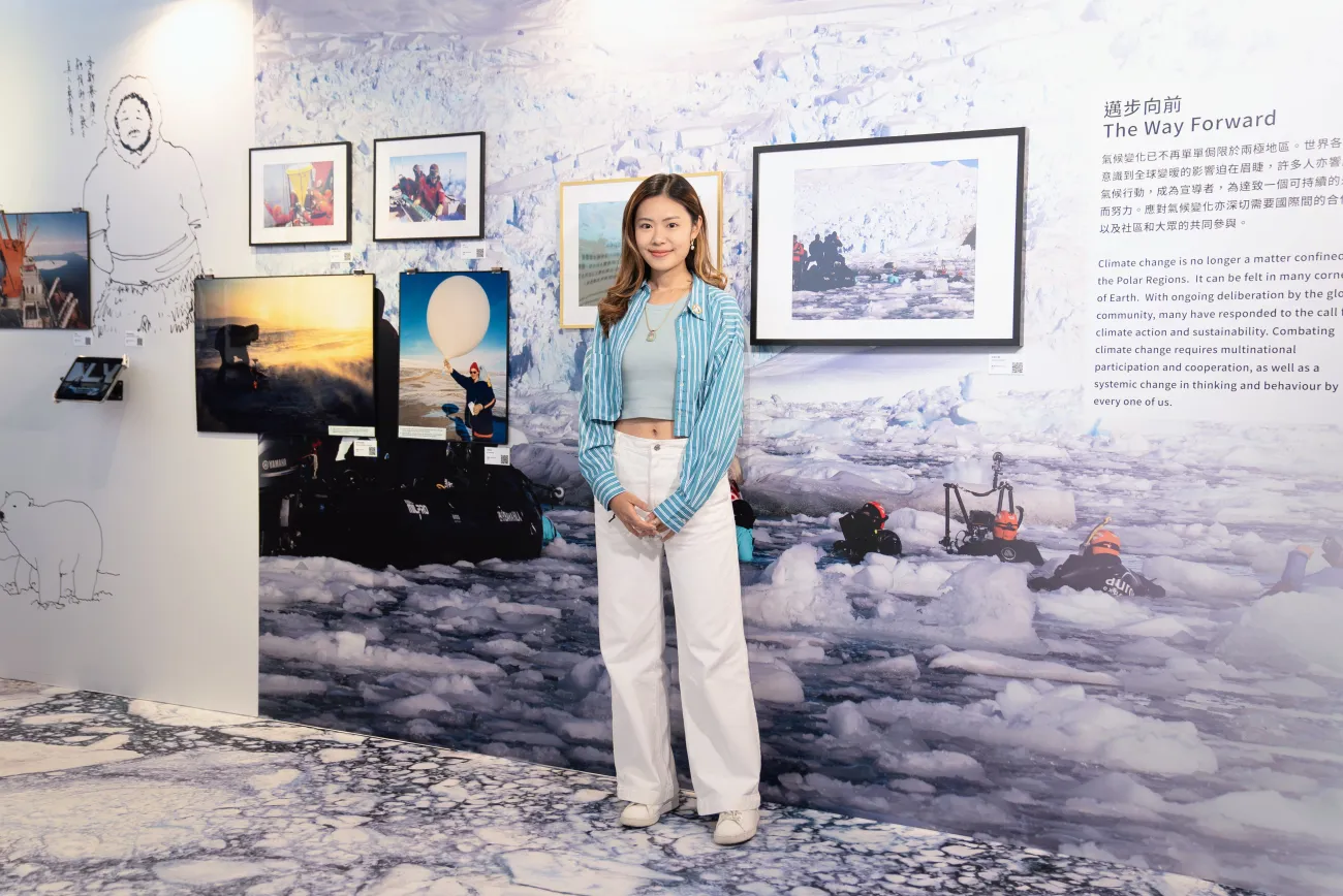 Natalie standing in front of her “Climate Witness: Changing Polar Landscapes” exhibition display