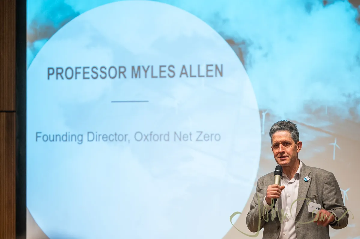 Prof Myles Allen at the front of a lecture theatre with a microphone