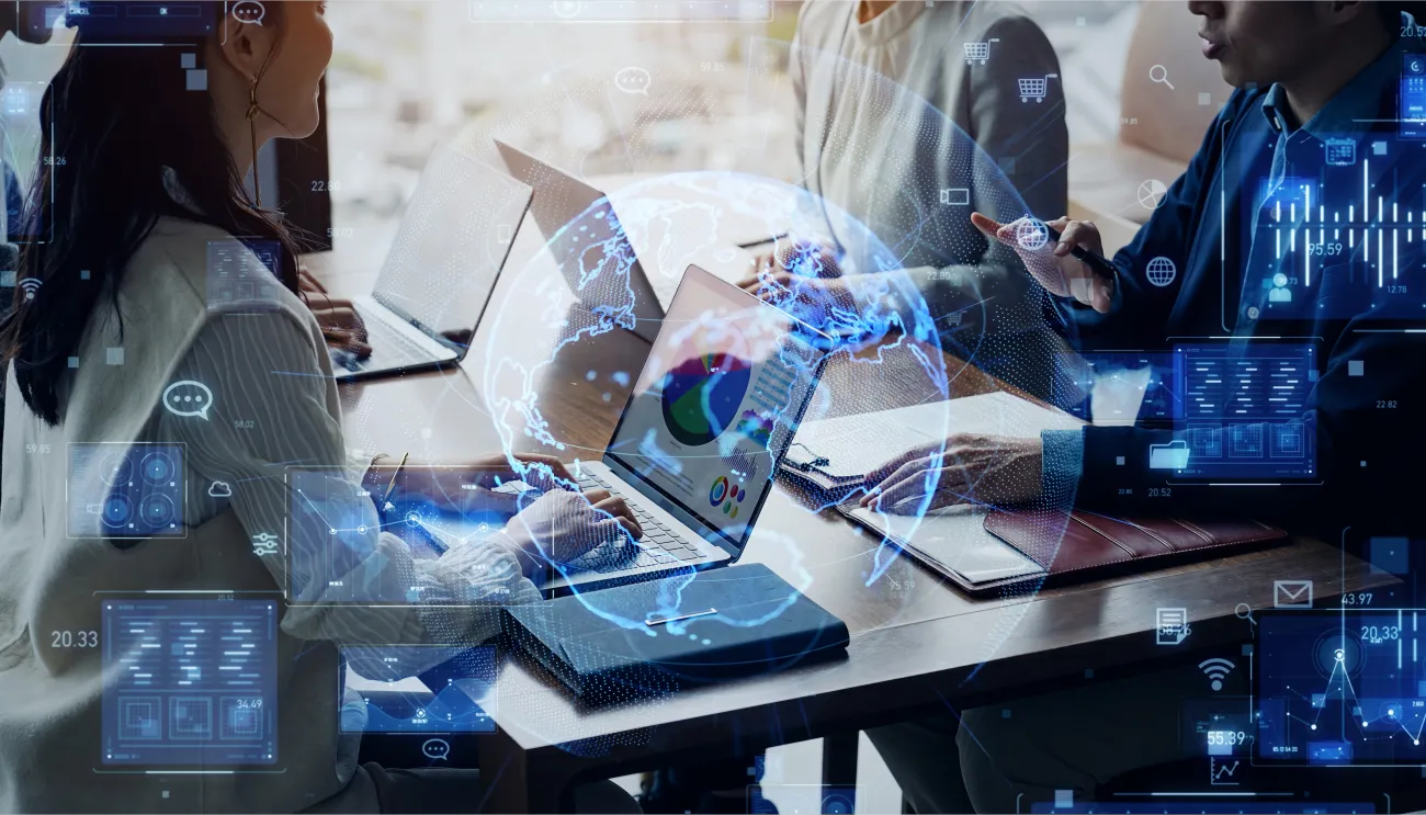 Group of business people in a meeting with laptops and overlaid maps and data suggesting AI at work