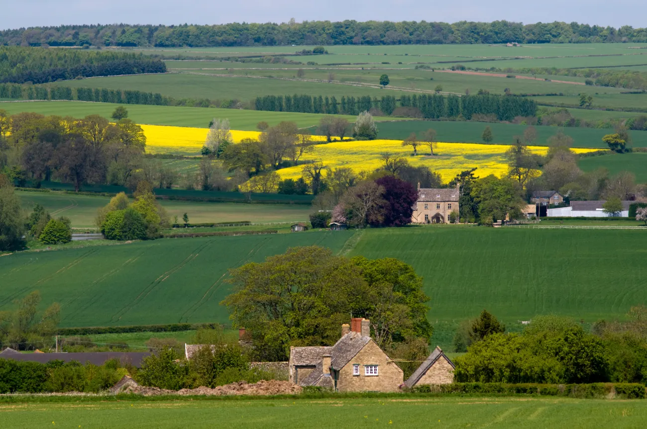 The view across the Glyme Valley in the Cotswolds, Oxfordshire in spring, with oilseed rape and mixed arable fields