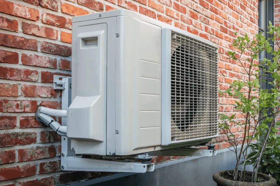 Heatpump attached to brickwork on side of a house