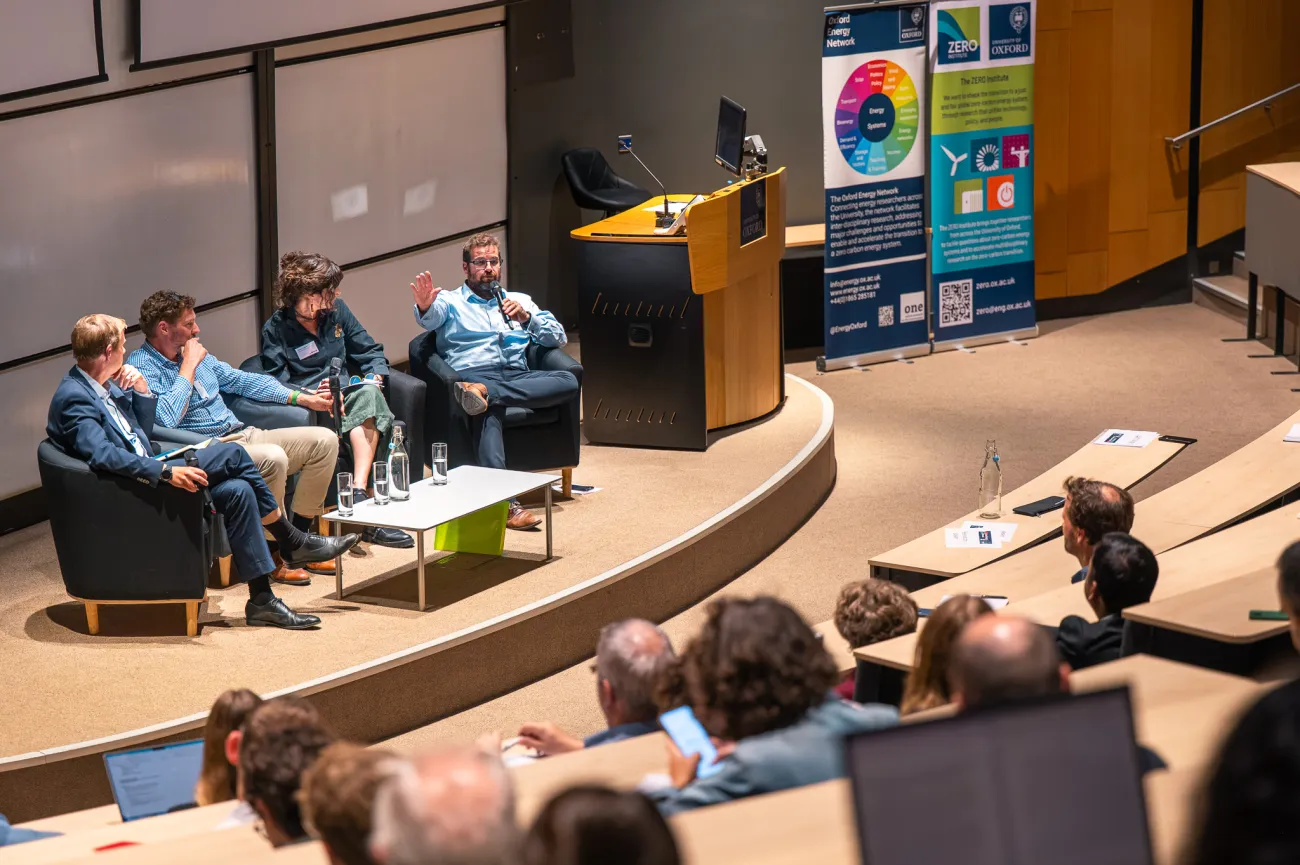Speaker panel sat in chairs on stage in lecture theatre