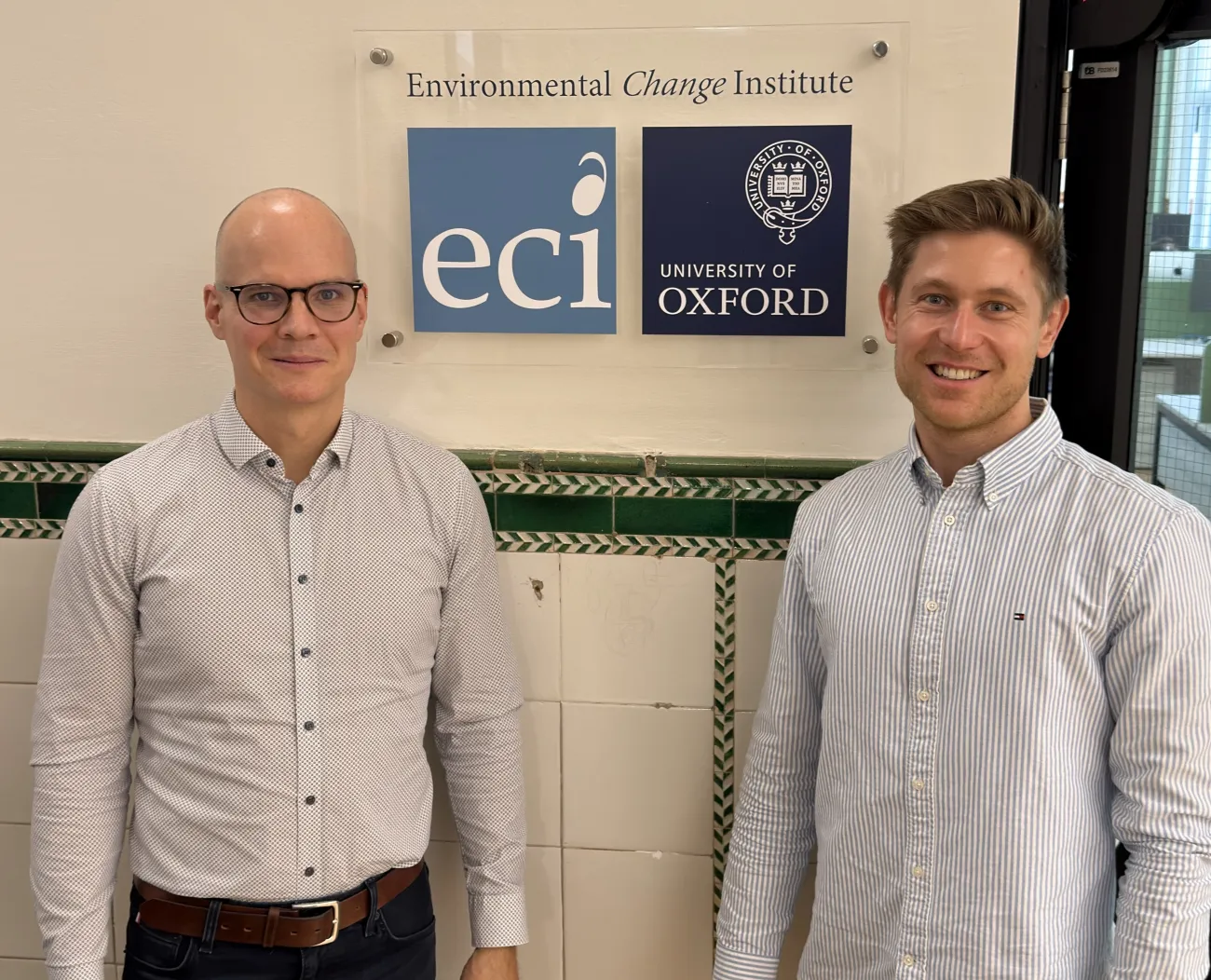 Prof Jan Rosenow stood next to Marcel Seger beneath the sign to the ECI department